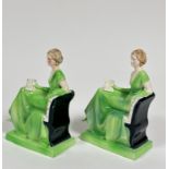 A Katzhutte pair of seated figures with arm outstretched holding a book, decorated with green glaze,