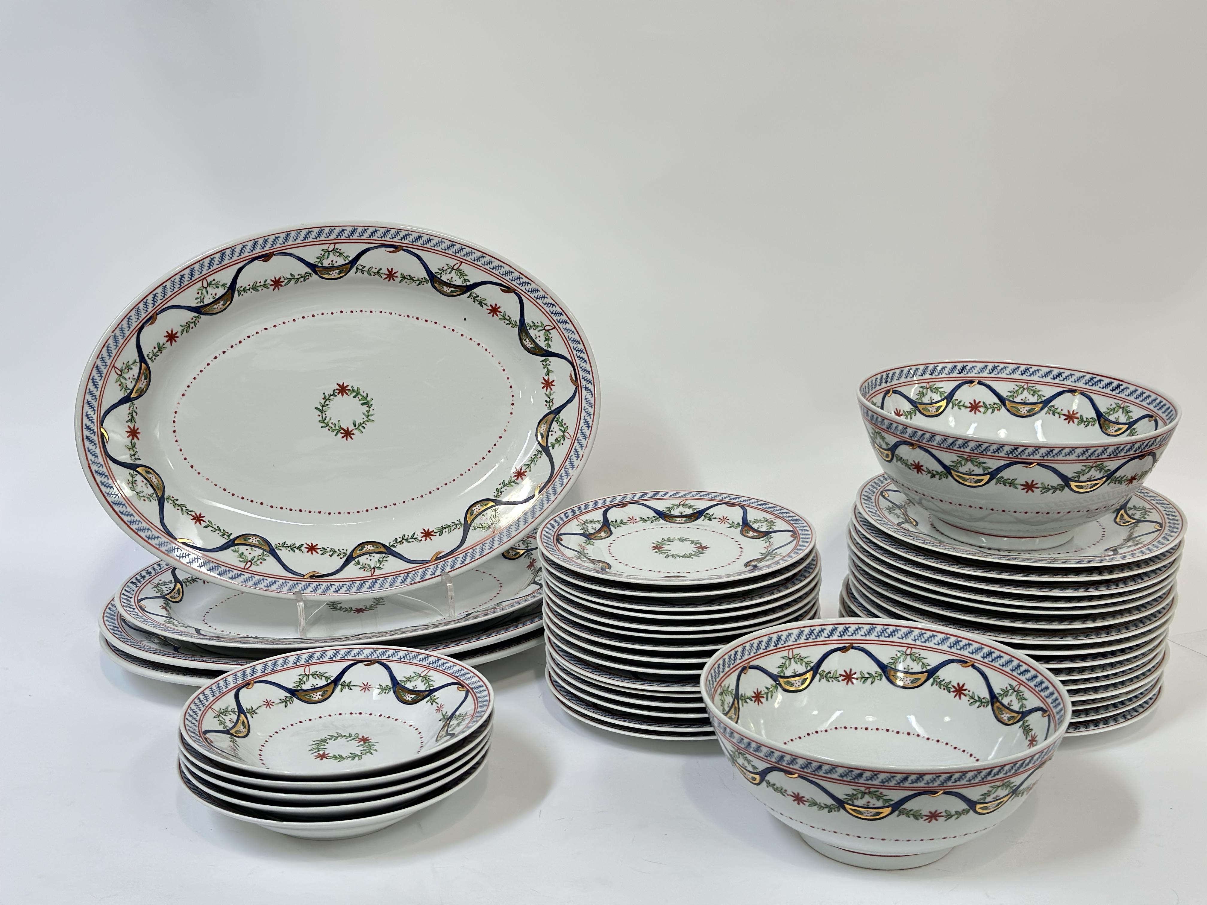 A Chinese porcelain part dinner service with polychrome decoration of floral swags and gilding