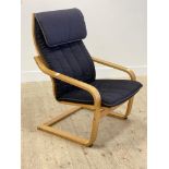 An Ikea Poang lounge chair, bent wood laminated frame supporting an upholstered seat cushion H101cm,