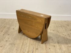 Ercol, a blonde elm drop leaf table, the oval top on pierced and shaped panel end supports, H46cm,