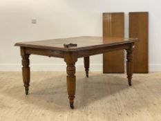 A late Victorian oak wind out extending dining table, the rectangular moulded top with canted