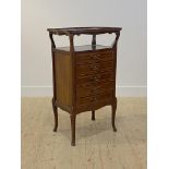 An Edwardian mahogany sheet music cabinet, the open tray top of serpentine outline over five fall