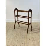 An Edwardian walnut towel rail, with six rungs raised on boxwood strung square splayed supports,