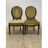 A pair of 19thc walnut side chairs, the oval back with spiral moulded show frame, over upholstered