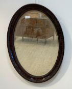 An Edwardian simulated rosewood composition oval wall hanging mirror, the frame with egg and dart