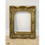 An ornate 19th century giltwood and composition picture frame in the Rococo taste, embellished