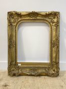 An ornate 19th century giltwood and composition picture frame in the Rococo taste, embellished