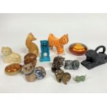 A collection of cat figures including a treen tabby cat, an upright standing blue glazed cat, a