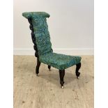 A Victorian ebonised and floral carved prie dieu chair, upholstered in later William Morris style