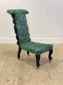 A Victorian ebonised and floral carved prie dieu chair, upholstered in later William Morris style