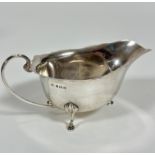 A Birmingham, 1929, George III style scalloped sauce boat, with C scroll handles to side and cast