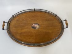 An Edwardian oak twin handled drinks tray of oval outline, having silver plated gallery W67cm,