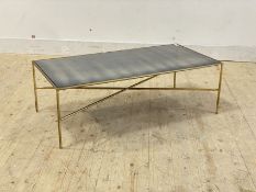A mid century style gilt metal coffee table, the distressed mirrored glass top raised on rod