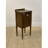 An early 20th century oak cabinet, with panelled door enclosing a shelf, raised on square tapered