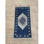 A North African hand knotted wool pile rug of geometric design 200cm x 102cm