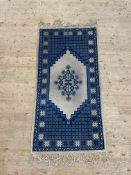 A North African hand knotted wool pile rug of geometric design 200cm x 102cm