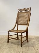 A late Victorian beech side chair, floral carved crest rail, cane seat and back, raised on turned