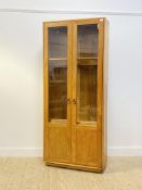 Ercol, a blonde elm display cabinet bookcase, two glazed doors enclosing an illuminated interior