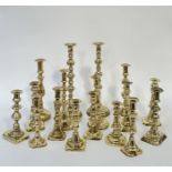 A group of brass candlestick holders comprising a large pair with faceted stem (h- 38cm), and a