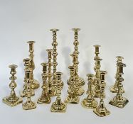 A group of brass candlestick holders comprising a large pair with faceted stem (h- 38cm), and a