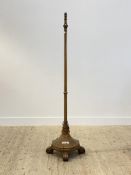 An early 20th century oak lamp standard, the ring turned column on a faceted octagonal base with