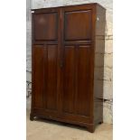 An Edwardian mahogany School cupboard, the twin panelled doors enclosing an interior fitted for