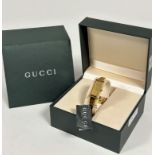 A Gucci gilt on stainless steel lady's quartz wristwatch with rectangular dial on metal stiff bangle