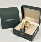 A Gucci gilt on stainless steel lady's quartz wristwatch with rectangular dial on metal stiff bangle