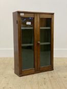An Edwardian bleeched mahogany wall hanging cabinet, two glazed doors enclosing two shelves H67cm,