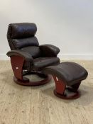 A Danish style reclining easy chair, upholstered in brown leather, raised on a circular swivel