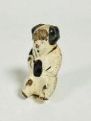 An 18/19thc Chinese seated pottery figure decorated with white and grey glaze, with pierced hole