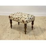 A Victorian stool, the seat covered in floral embroidered cotton, raised on turned supports,