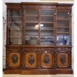 A large Edwardian mahogany break front bookcase, egg and dart moulded cornice over floral carved