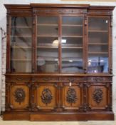 A large Edwardian mahogany break front bookcase, egg and dart moulded cornice over floral carved