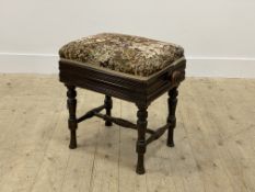 A Victorian walnut rise and fall piano stool, with upholstered seat, raised on turned supports,