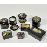 A group of four black enamelled powder pots decorated with transfer printed fish, handpainted