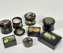 A group of four black enamelled powder pots decorated with transfer printed fish, handpainted