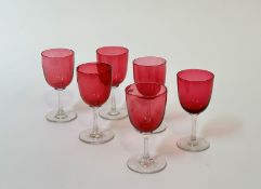 A set of six Edwardian cranberry clear cut glass wine glasses. (h- 13cm) (6)