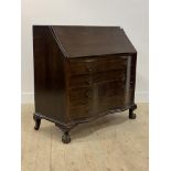 A 20th century mahogany bureau, the fall front revealing fitted interior, over four serpentine