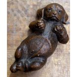 A decorative Continental Black Forest style carved wood figure of a dog with inset glass eyes (