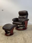 A Danish style reclining easy chair, upholstered in brown leather, raised on a circular swivel