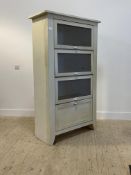 A 1950's style painted pine meat safe, with three up and over doors over a fall front door, raised