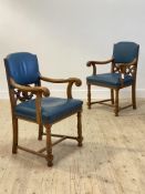 A pair of late Victorian oak library chairs, the back and seat upholstered in studded blue faux