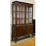 A George III style mahogany bookcase, two glazed doors opening to two fixed shelves, twin panelled