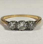 An 18ct gold and platinum three stone graduated diamond ring mounted in claw setting, the centre