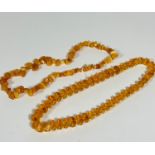 A strand of Lithuanian yolk coloured amber irregular shaped beads (31cm) and a clear faceted amber