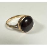 A garnet cabouchon ring mounted in 9ct gold setting rub over setting, (d: 1.3cm) foiled back (Q) (