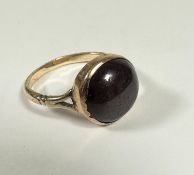 A garnet cabouchon ring mounted in 9ct gold setting rub over setting, (d: 1.3cm) foiled back (Q) (