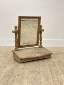A pine dressing table mirror, the bevelled glass swivelling between turned uprights over a trinket