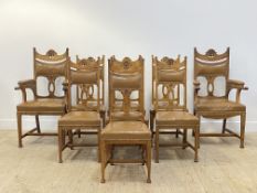 A set of nine (7+2) Arts and Crafts period oak dining chairs, floral pierce carved crest rail over